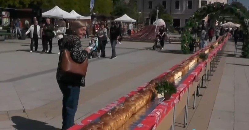 На централния площад във Враца хората празнуват с 100-метров козунак. Прави